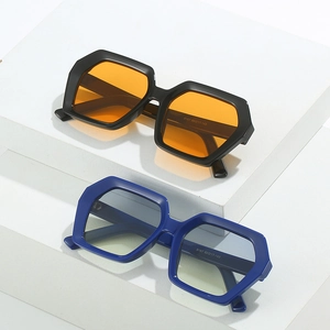 Modern oversized geometric sunglasses with vibrant lenses on a minimalist white pedestal