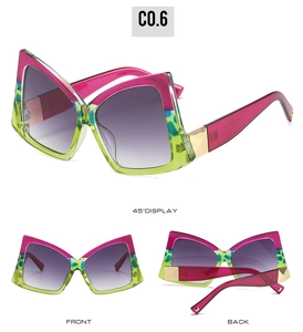 Lunettes de soleil papillon surdimensionnées à la mode avec monture rose et verte.