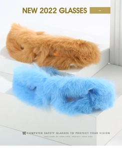 Close-up of fluffy faux fur sunglasses in camel and bright blue on a geometric background