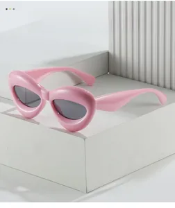 Detail of pink cat-eye sunglasses with thick frame on a modern geometric display