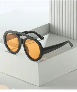 Close-up of retro oversized black frames with transparent orange lenses and double bridge