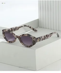 Macro shot of tortoiseshell cat-eye sunglasses featuring golden diamond-shaped temple logo