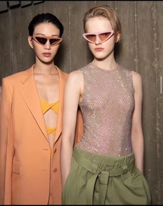 Close-up of models wearing luxury geometric triangle sunglasses with colorful frames