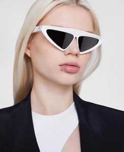Close-up of white thick-framed triangle cat eye sunglasses worn by a fashion model
