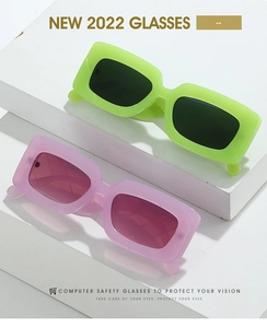 Detail view of colorful retro square frame glasses in neon green and translucent lilac