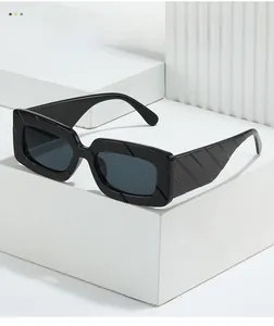 Detailed close-up of wide temple with diagonal textured relief on black square sunglasses