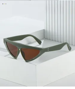 Detail of dark green triangle sunglasses frame with metal accents on light background