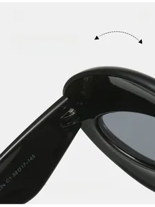 Detail of the durable metal hinge and size specifications on black cat-eye sunglasses