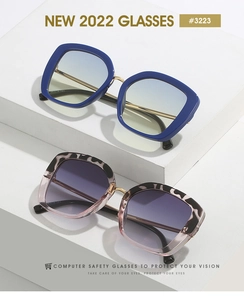 Detail view of square frame glasses with matte blue and leopard patterns on display steps