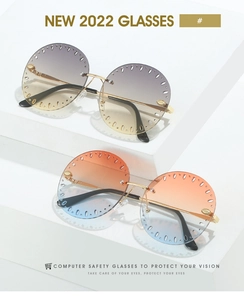 Détail de lunettes de soleil rondes sans monture avec verres dégradés et décor ajouré