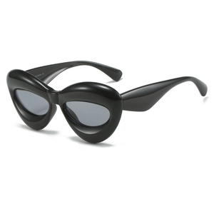 Black avant-garde cat-eye sunglasses with thick teardrop frames and dark grey lenses