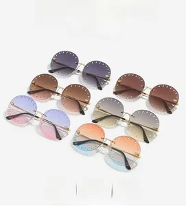 Détail des lunettes de soleil rondes sans monture avec bords ajourés et pont doré