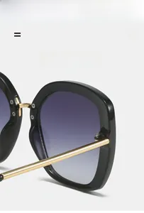 Detail of square sunglasses hinge with gold metal temples and blue gradient lenses