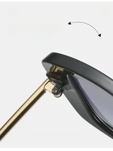 Detail view of the durable golden metal hinges and purple lenses on black square sunglasses