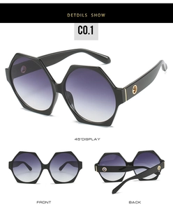 Detail view of oversized polygon sunglasses with purple gradient lenses and gold accents