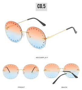 Détail de lunettes de soleil rondes sans monture avec dégradé orange-bleu et découpes