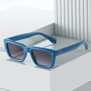 Lunettes de soleil carrées bleu foncé avec rivets argentés sur support blanc épuré