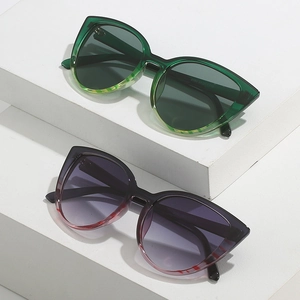 Lunettes de soleil œil-de-chat tendance pour femmes sur socles blancs avec dégradé chic