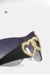 Detail of golden heart-shaped metal inlay on black temples of Y2K sunglasses