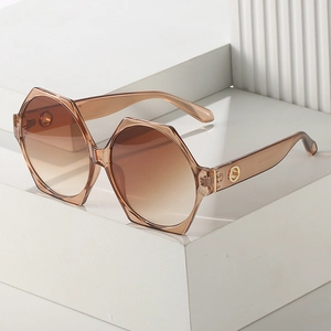 Chic oversized geometric amber sunglasses with gradient lenses on minimalist stone display