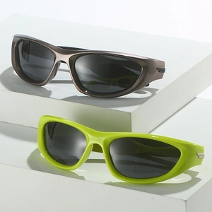 Polarized sports sunglasses in brown and neon green on a white geometric stand