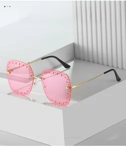 Detailed close-up of pink gradient rimless sunglasses with hollow decorative rhinestones