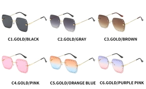 Detail of rimless square sunglasses with hollowed lens edges and gold metal temples
