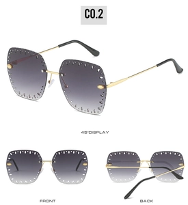 Detail view of rimless gradient grey sunglasses with circular cut-outs and golden metal temples