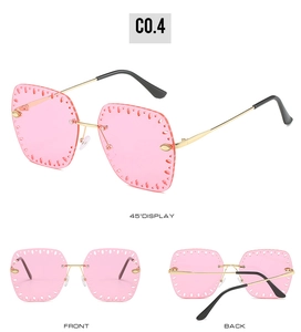 Detail view of pink rimless sunglasses with gold metal temples and hollow lens edges