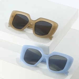 Stylish square frame sunglasses in amber and light blue on minimalist white blocks