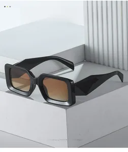 Detail of black square sunglasses with brown gradient lenses on geometric stone display