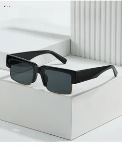 Detail of square vintage sunglasses with thick black upper frame and gold metal lower trim