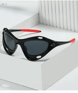 Close-up of futuristic Y2K sports sunglasses with black frames and red rubber tips