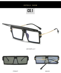 Detail of vintage oversized flip-up sunglasses with black frames and gold metal temples