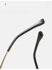 Close-up of curved glossy black sunglass arms with reinforced gold metal hinges