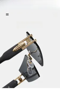 Detail of rimless sunglasses with gold cross emblem on black temple and grey lens