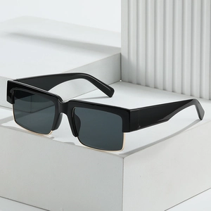 Square black sunglasses with metal trim on white geometric stand for street style