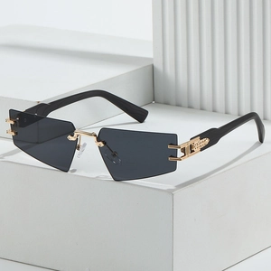 Frameless triangle sunglasses with grey lenses and gold metal temples on a white podium