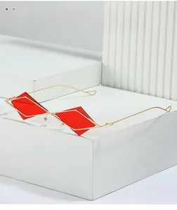 Makroaufnahme der geometrischen roten rautenförmigen Gläser mit dünnem goldenem Metallrahmen