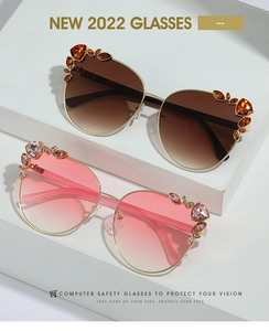 Detail view of oversized cat-eye sunglasses with rhinestone edges on white steps