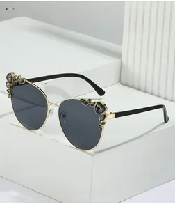 Detail showing oversized cat-eye sunglasses with rhinestone inlay on white props