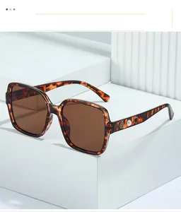 Détail de lunettes de soleil écailles avec rose dorée, perle et cœur sur les branches