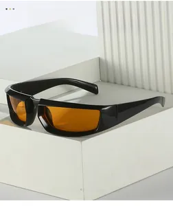 Détail de lunettes de soleil carrées à monture noire et verres orange sur socle