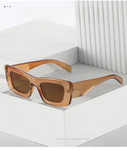 Detail of dark amber rectangle sunglasses with thick acetate frame on white podium