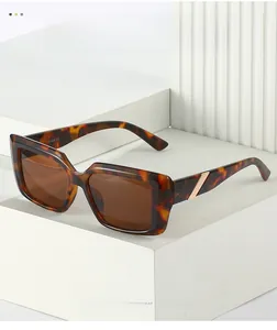 Detail of tortoise square sunglasses with gold metal accents on white geometric steps
