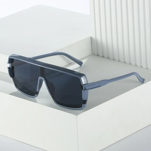 Modern grey-blue flat top oversized sunglasses shown on white geometric display stand