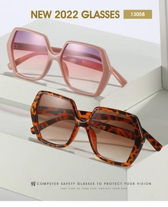 Detail view of hexagonal sunglasses in pink and tortoise frames on geometric pedestals