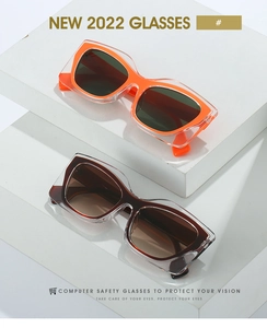 Detail of chunky cat-eye sunglasses with thick transparent frames and vibrant inner colors