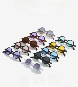 Flat lay of multiple retro small frame polygon sunglasses in various colorful lenses