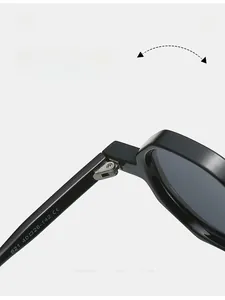 Detailed close-up of metal hinge and CE marking on black oval acetate frame sunglasses